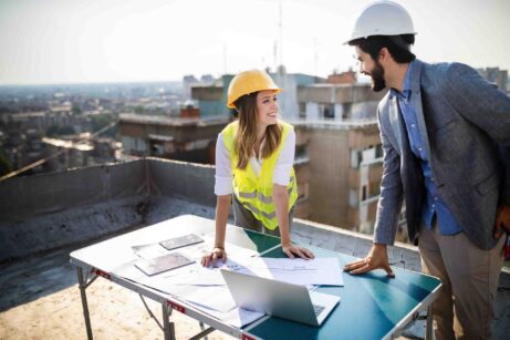 tým architektů kontrolující dokumenty na stavbě